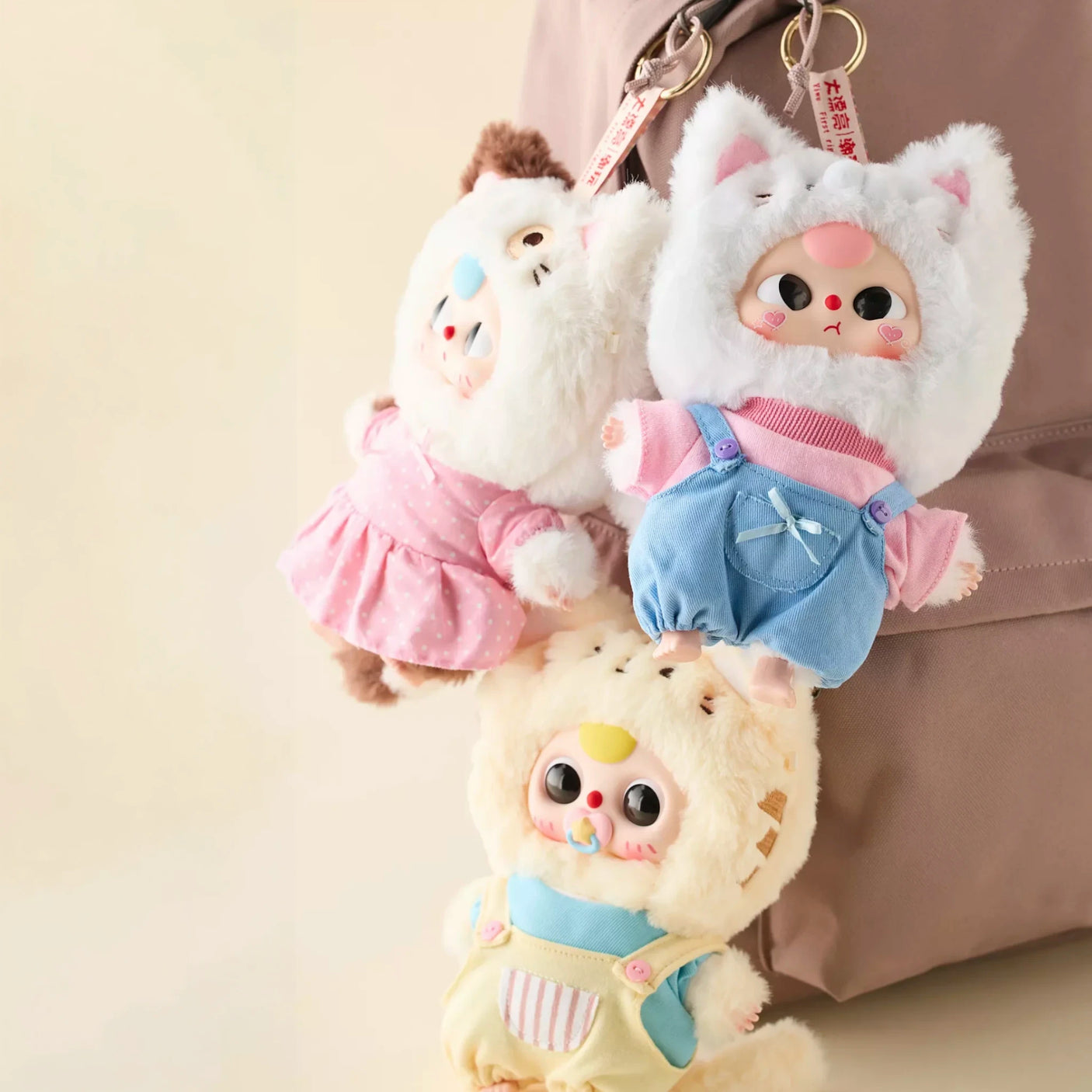 Three Baby Three - Kitten Wardrobe Keychain Blind Box dolls in colorful cat costumes hanging on a bag ring clasp