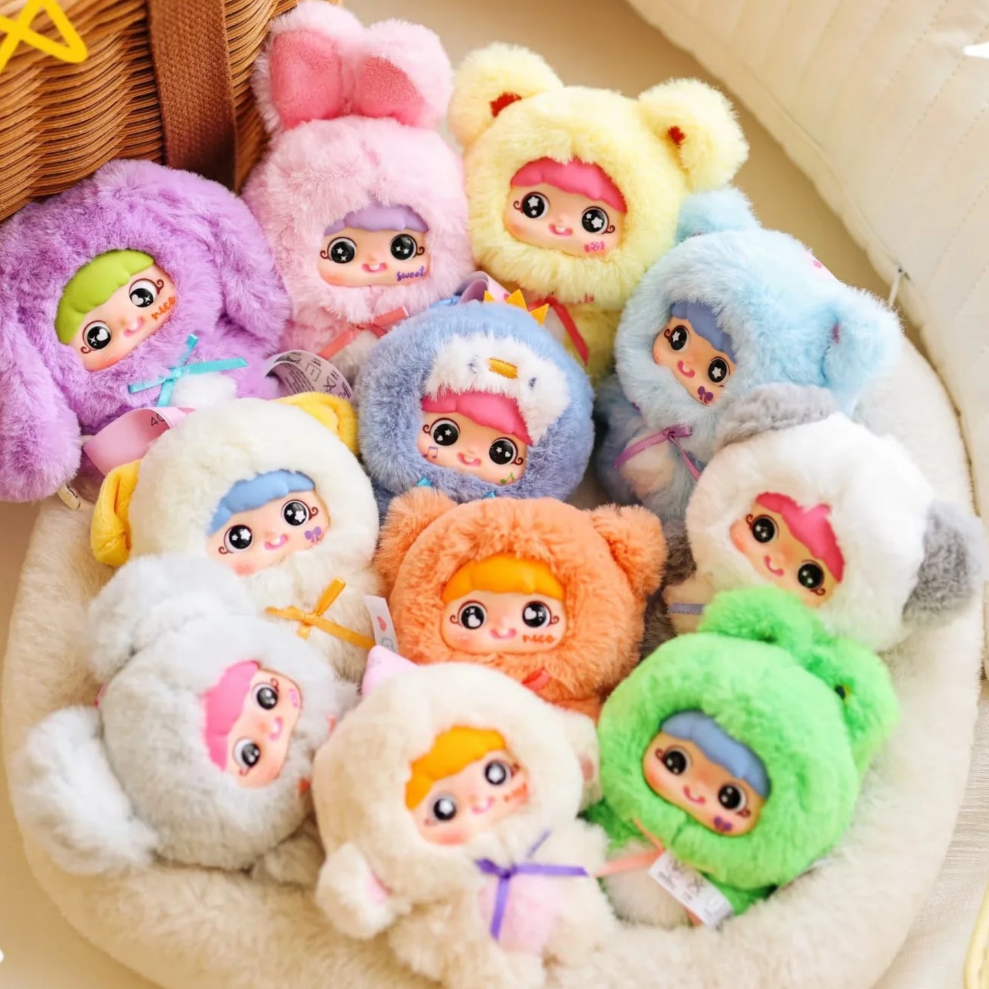 Assorted pastel plush character pendants in a round tray, each with a big cute face