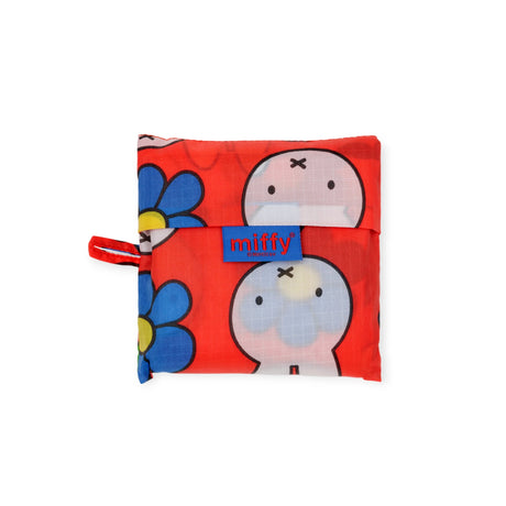 The Standard Baggu x Miffy Flower is a red foldable reusable bag from Baggu, decorated with blue flowers and Miffy illustrations, and finished with a "miffy" branded label on the front.