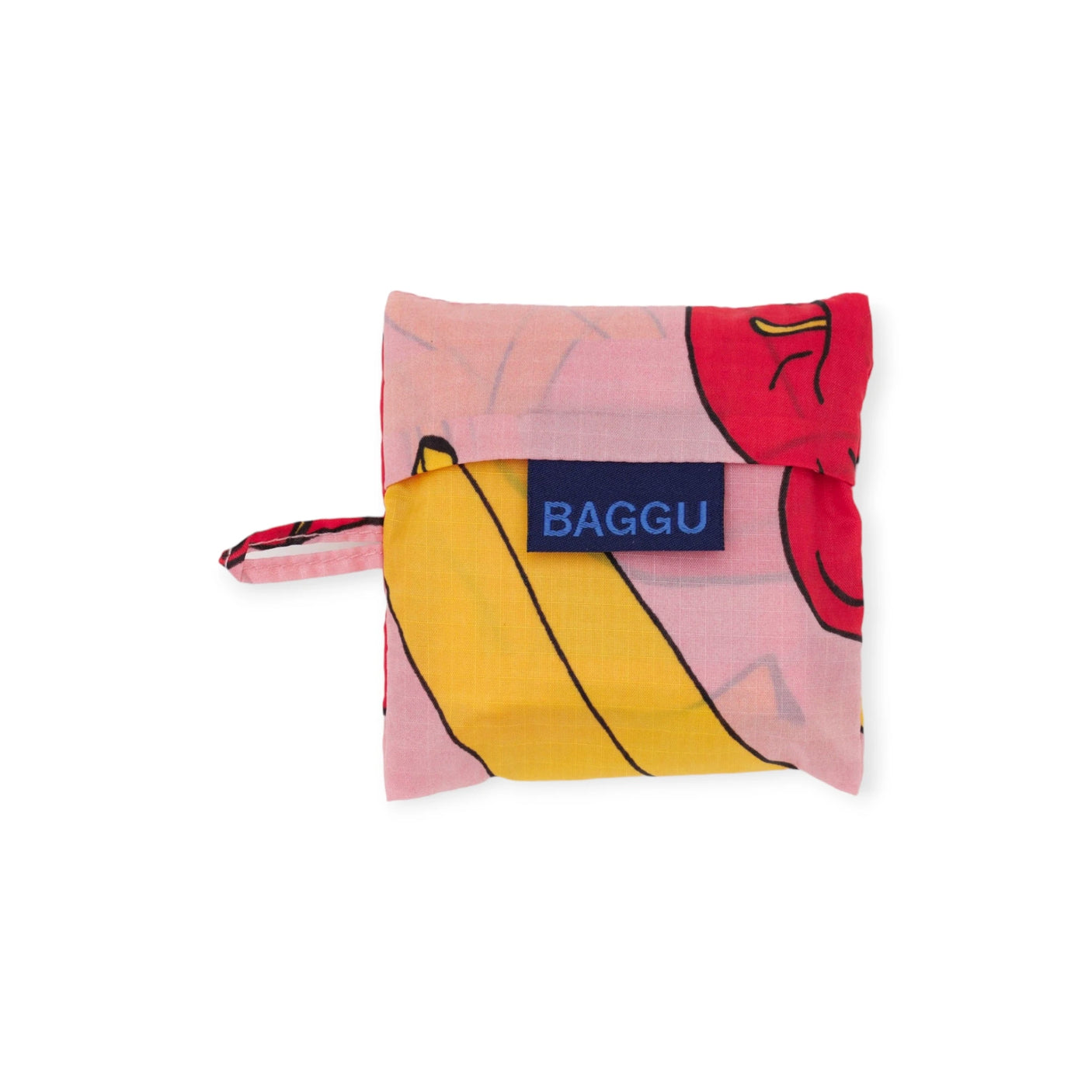 The Baby Baggu Reusable Bag from Baggu is made of recycled nylon and folds into a compact pocket shape. It features a lively pink apples & bananas print, along with a blue "BAGGU" label.