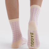 Crew socks with houndstooth and Baggu text at the cuff, tan toe