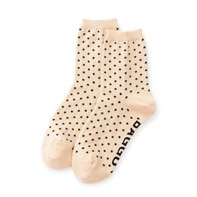 Pair of cream crew socks with black micro polka dots and Baggu logo text