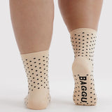 Cream crew socks with black micro polka dots and Baggu logo on heel