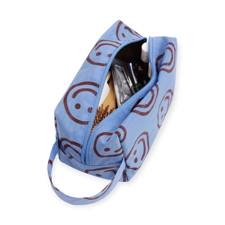 Light blue toiletry dopp kit with smiley pattern, open top and zipper closure