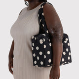 Black polka-dot tote bag with cream dots, short handles