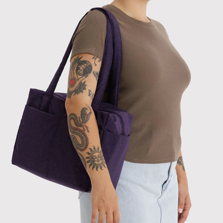Baggu cloud tote in fig purple, carried on shoulder with wide straps