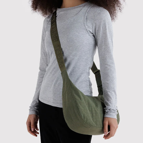 Medium crescent crossbody bag worn with long adjustable strap, dark green nylon