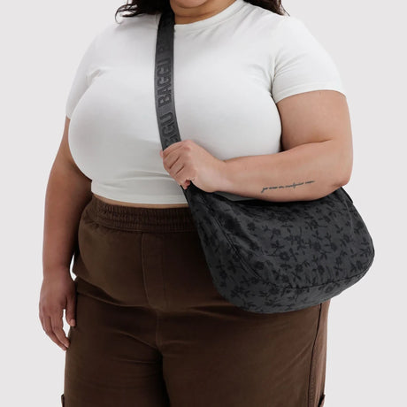 Medium crescent nylon shoulder bag worn crossbody, dark charcoal floral print
