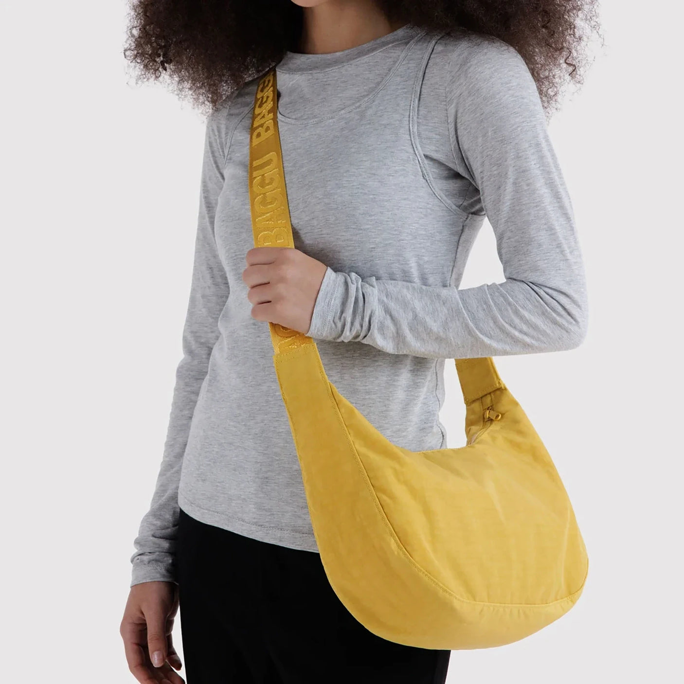 Sunflower yellow nylon crescent bag worn on shoulder with long strap