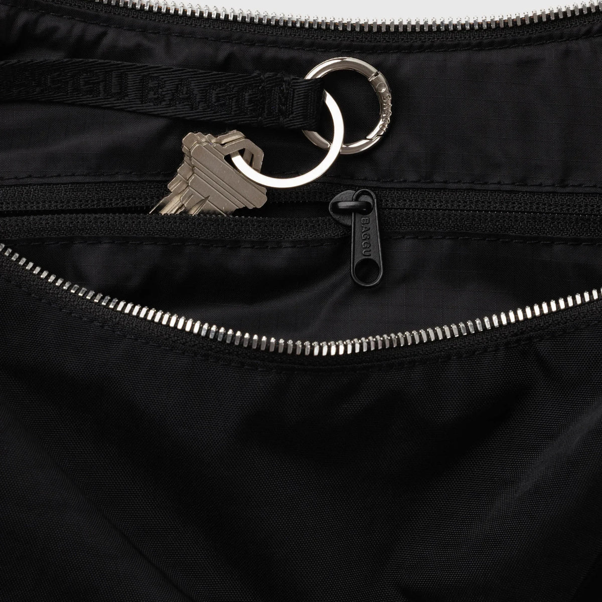 Black nylon crescent bag with zip top and metal keyring pull
