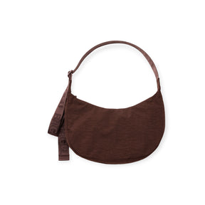 Dark brown crescent-shaped fabric shoulder bag with single strap and decorative fabric ribbon detail on white background