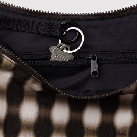 Close-up of black zippered interior pocket with keyring holding two silver keys inside patterned fabric bag