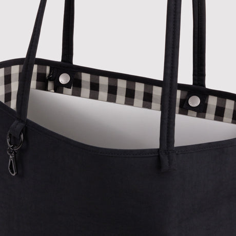 Nylon tote top detail: black handles, gingham lining, and snap buttons