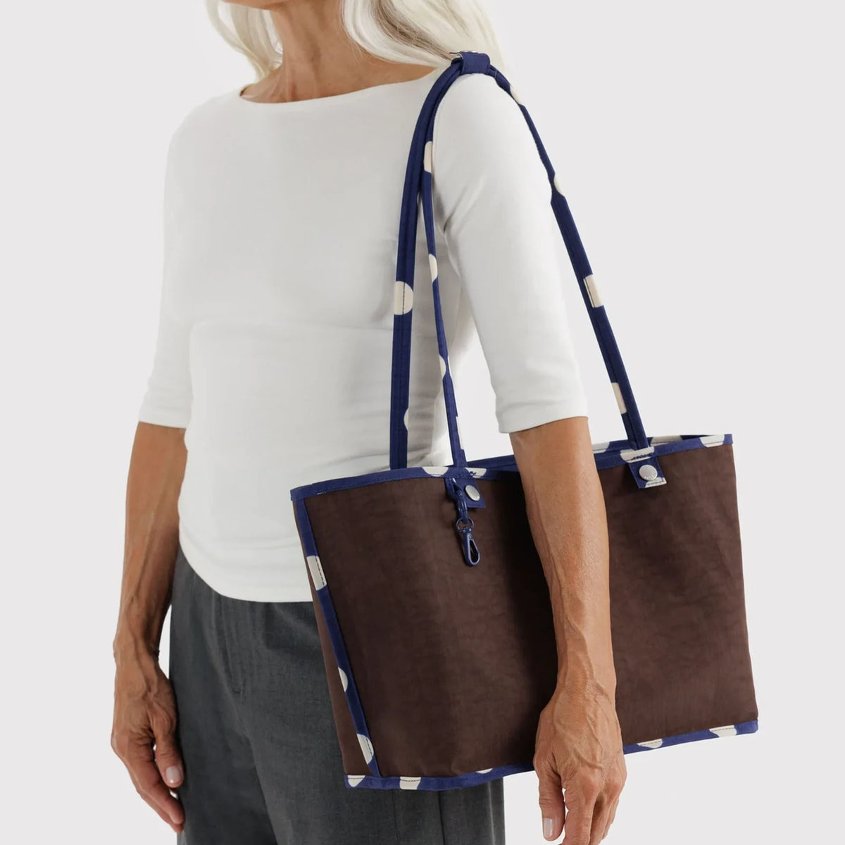 Reversible nylon tote worn, brown exterior with navy trim and carrying straps