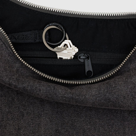 Interior view of washed black denim Baggu Medium Crescent Bag showing key leash with attached keys and zippered pocket, gallery position 1