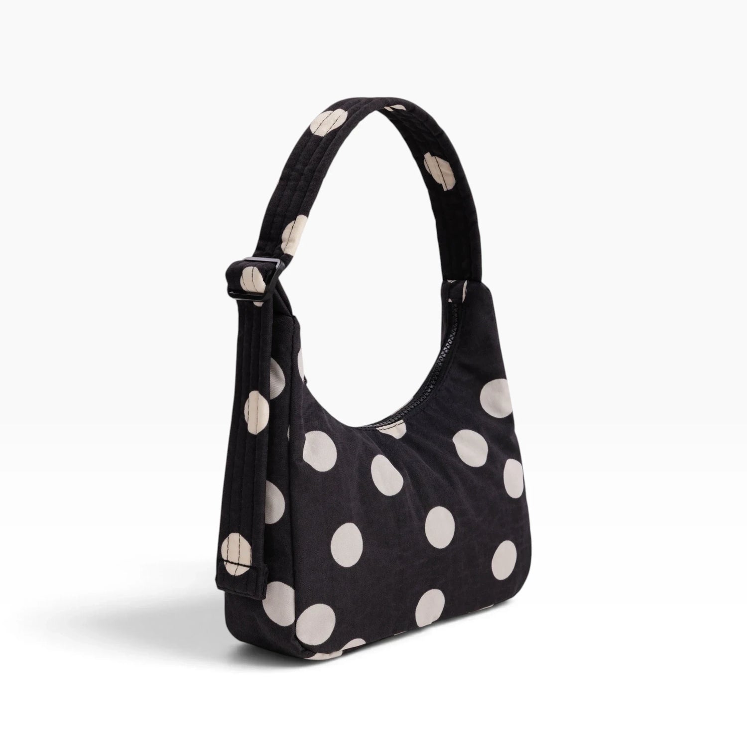 Black mini shoulder bag with cream polka dots and adjustable top strap
