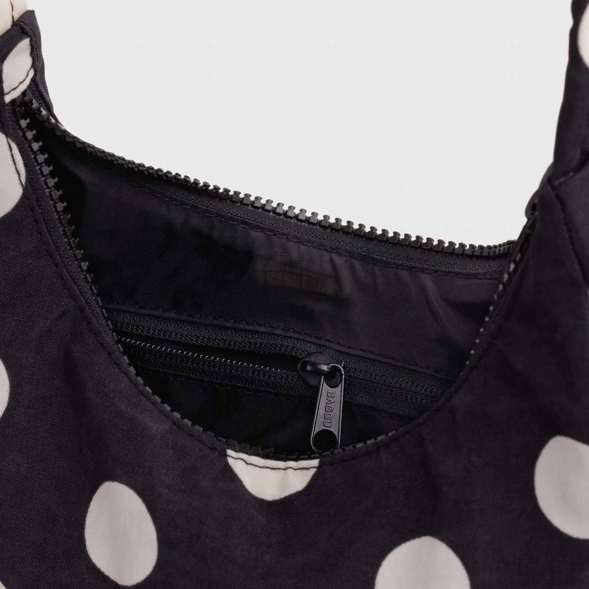 Black nylon mini shoulder bag interior with zipper pocket and zip opening