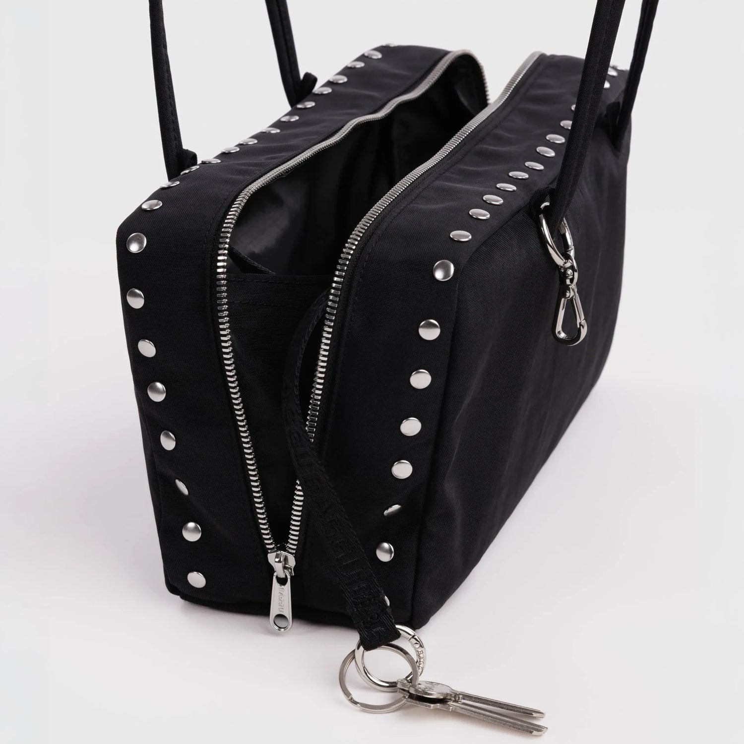 Black bowler bag open view, studded zipper fronts and metal keyring clasp