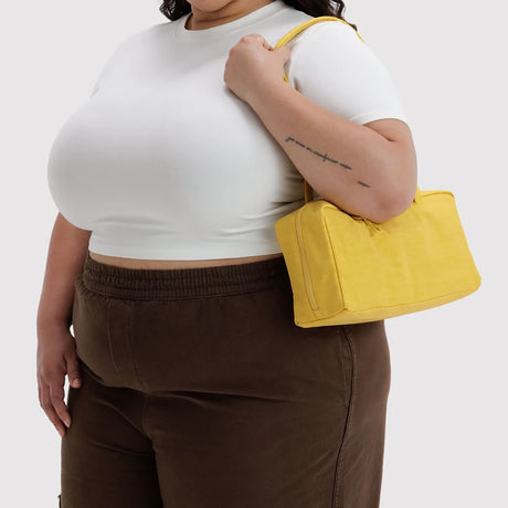 Sunflower yellow nylon bowler bag held at side with short handles and zipper opening