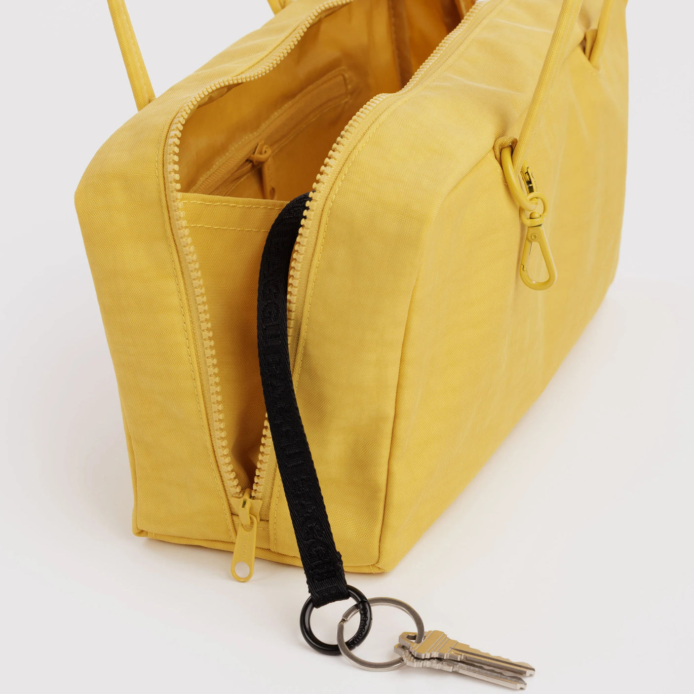 Open sunflower yellow bowler bag with zipper, interior pocket, and key clip