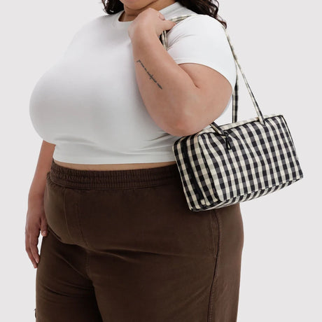 Black and cream gingham bowler bag worn crossbody, side view