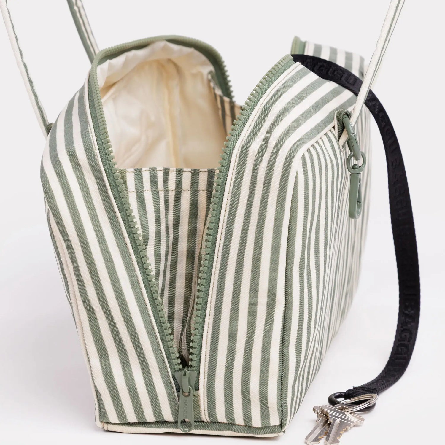 Sage-striped nylon bowler bag with zip top and green trim, side strap and metal hardware