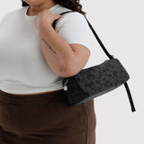 Charcoal crossbody nylon loaf bag with dark floral print, zipped top and key tag
