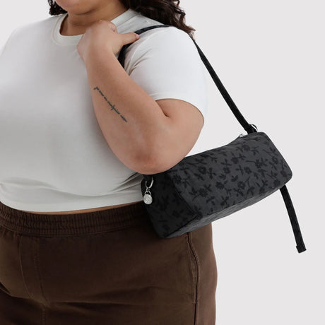 Charcoal crossbody nylon loaf bag with dark floral print, zipped top and key tag