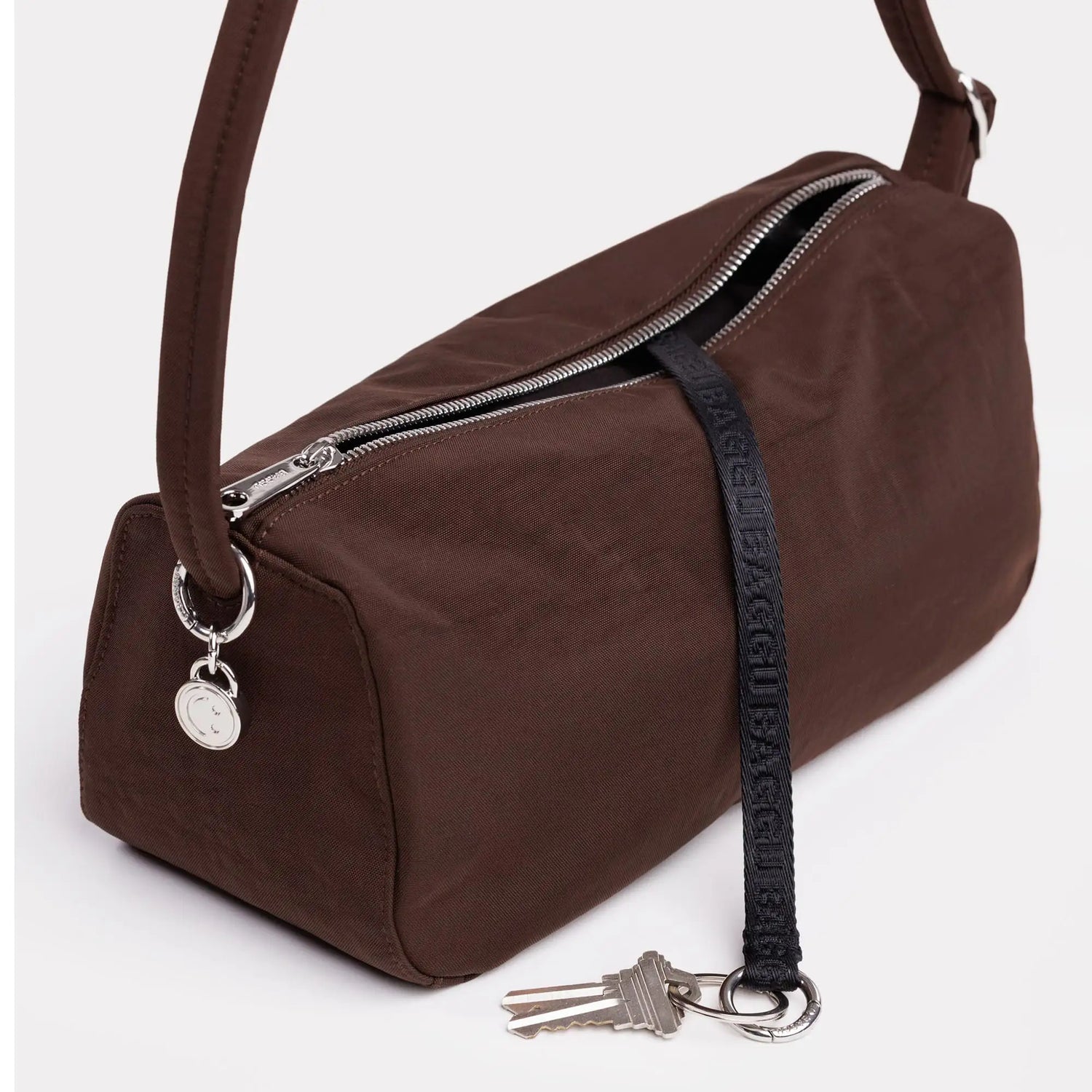 Coffee-brown nylon loaf bag with front zipper, metal rings, and key-fob charm