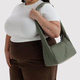 Olive green nylon slouch bag carried on shoulder with top handles