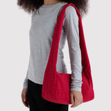 Cherry red nylon shoulder tote bag worn on shoulder, open top with wide base