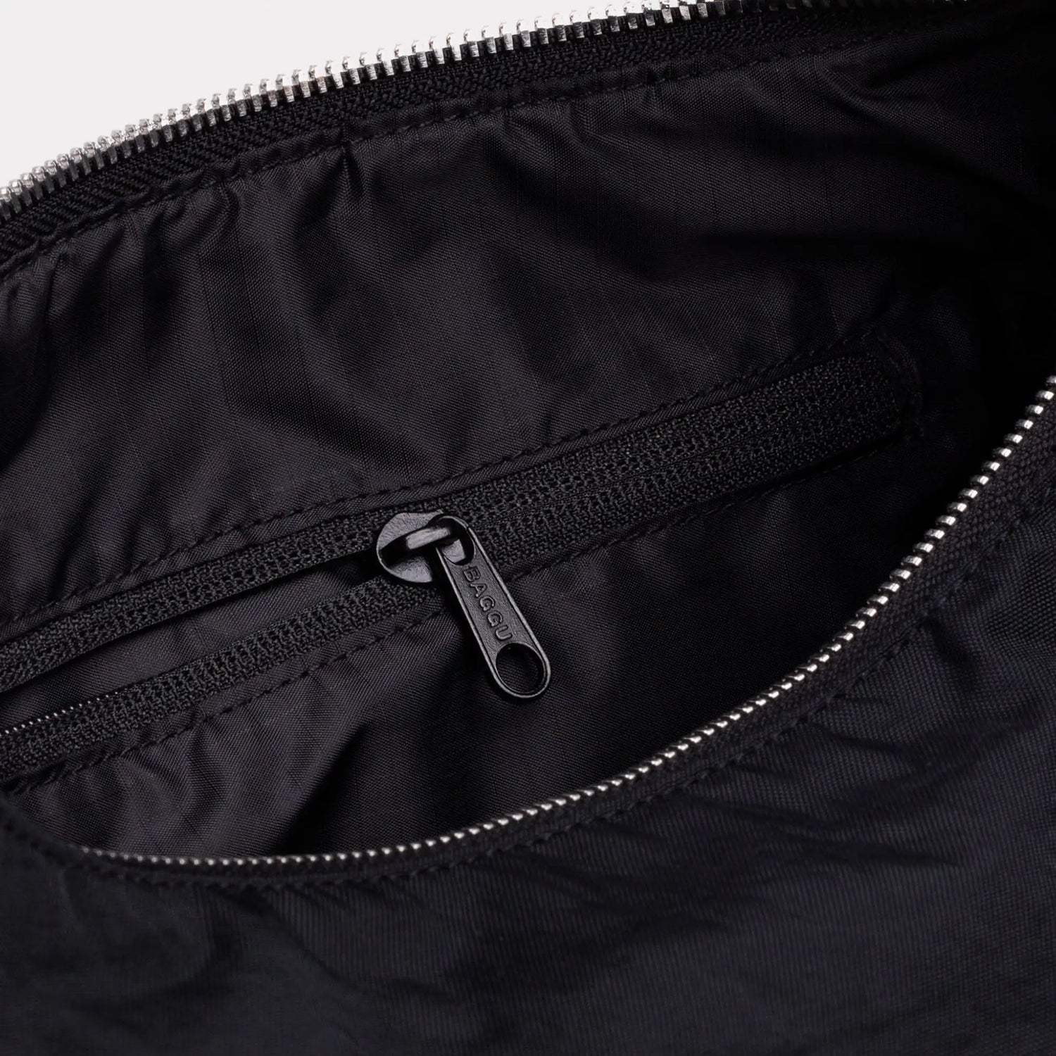 Black nylon bag interior with zip pocket and metal zipper pull