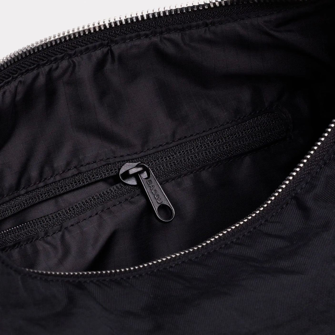 Black nylon bag interior with zip pocket and metal zipper pull