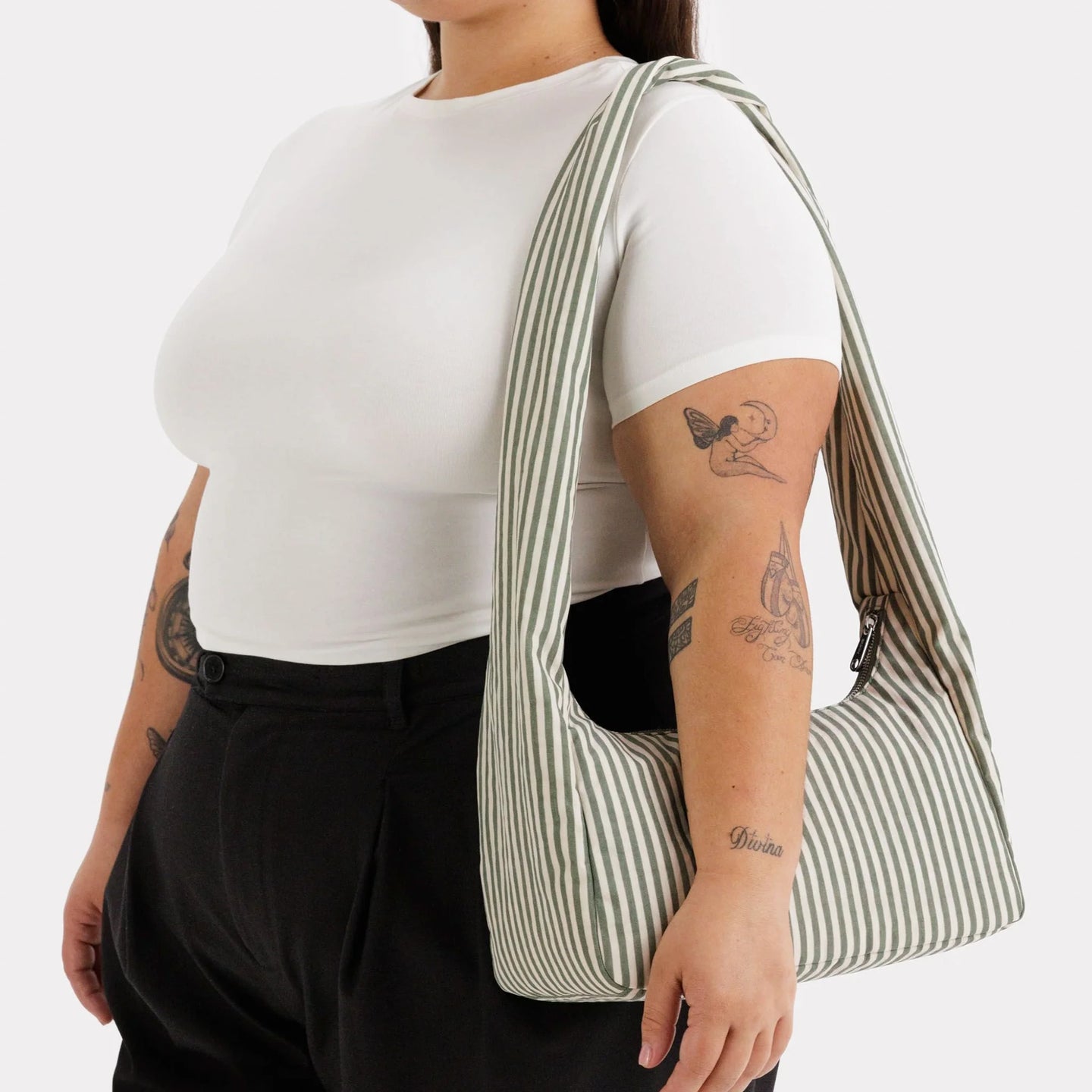 Baggu nylon meringue bag, sage green striped hobo shoulder style on model