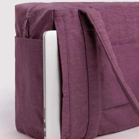 Plum carry-on tote bag close-up with side zipper, inner sleeve, and long strap