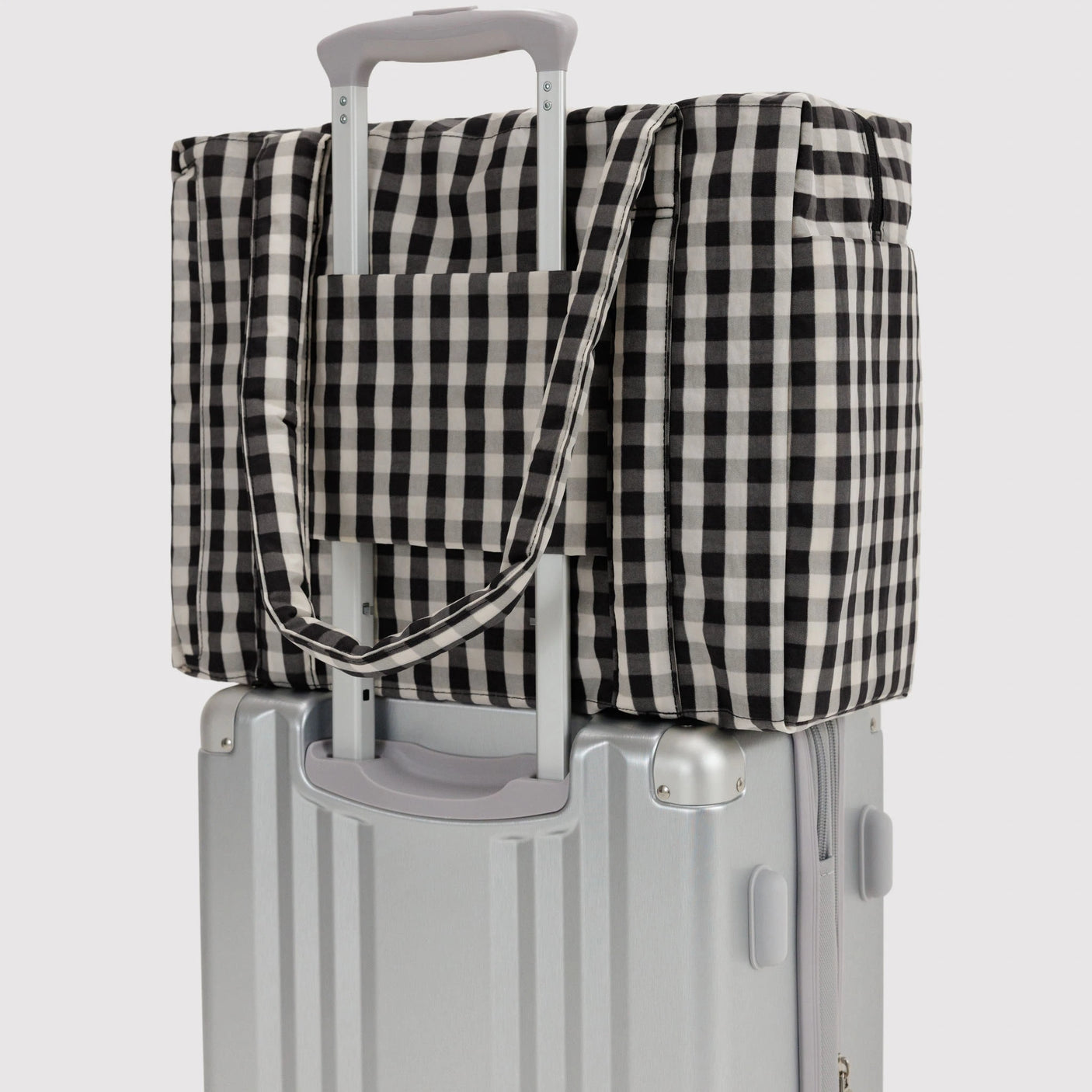 Baggu small carry-on bag, black-and-cream gingham, over rolling handle with strap