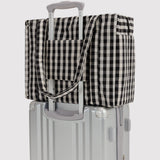 Baggu small carry-on bag, black-and-cream gingham, over rolling handle with strap