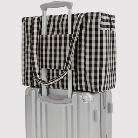 Baggu small carry-on bag, black-and-cream gingham, over rolling handle with strap