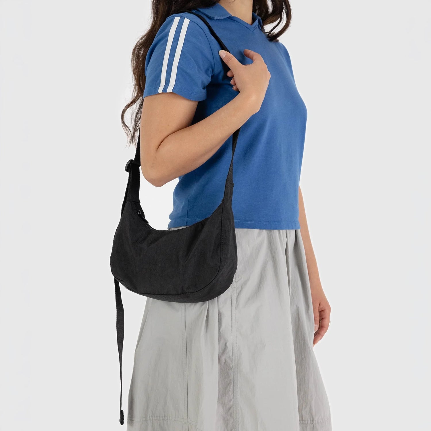 Black small nylon crescent bag worn crossbody with long adjustable strap
