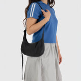 Black small nylon crescent bag worn crossbody with long adjustable strap