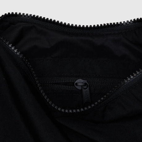Black nylon crescent bag interior with zipper and stitched logo patch