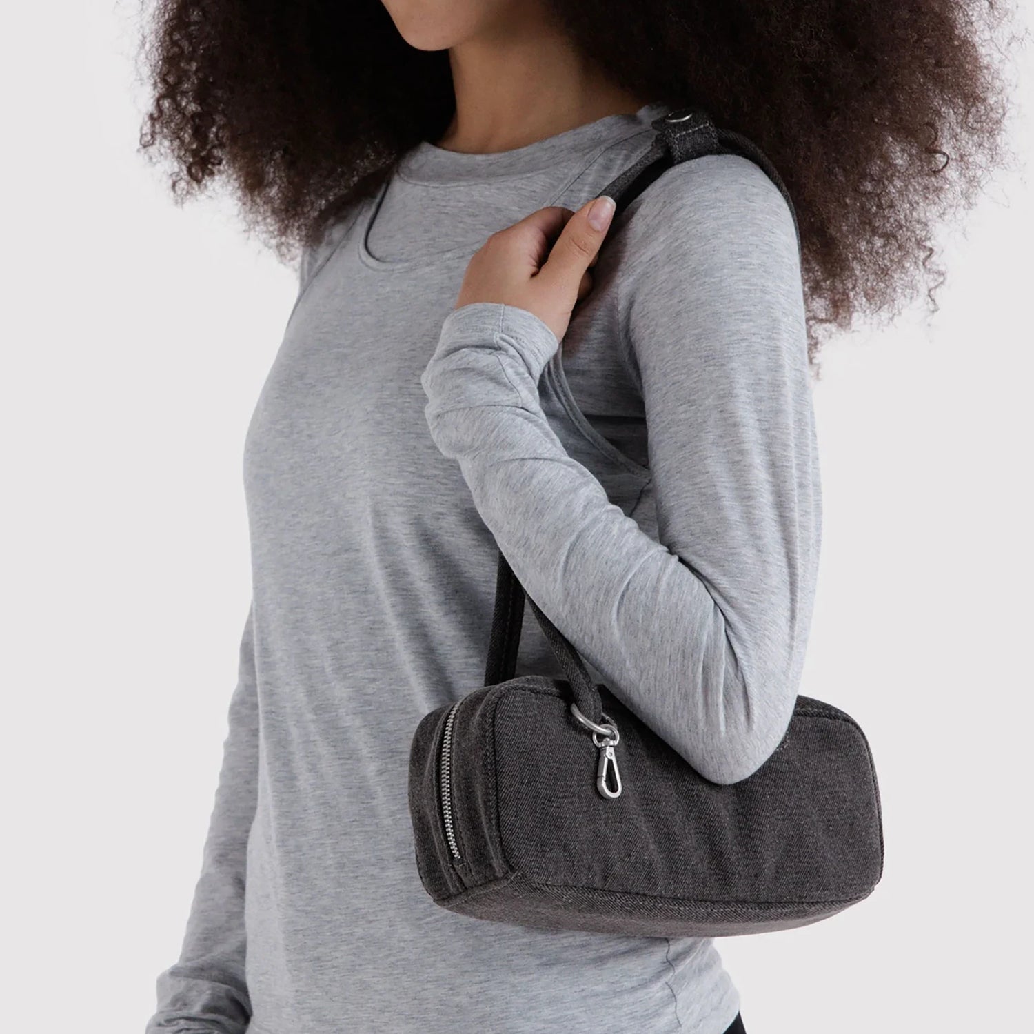 Small washed black denim bowler bag carried on shoulder with top zipper
