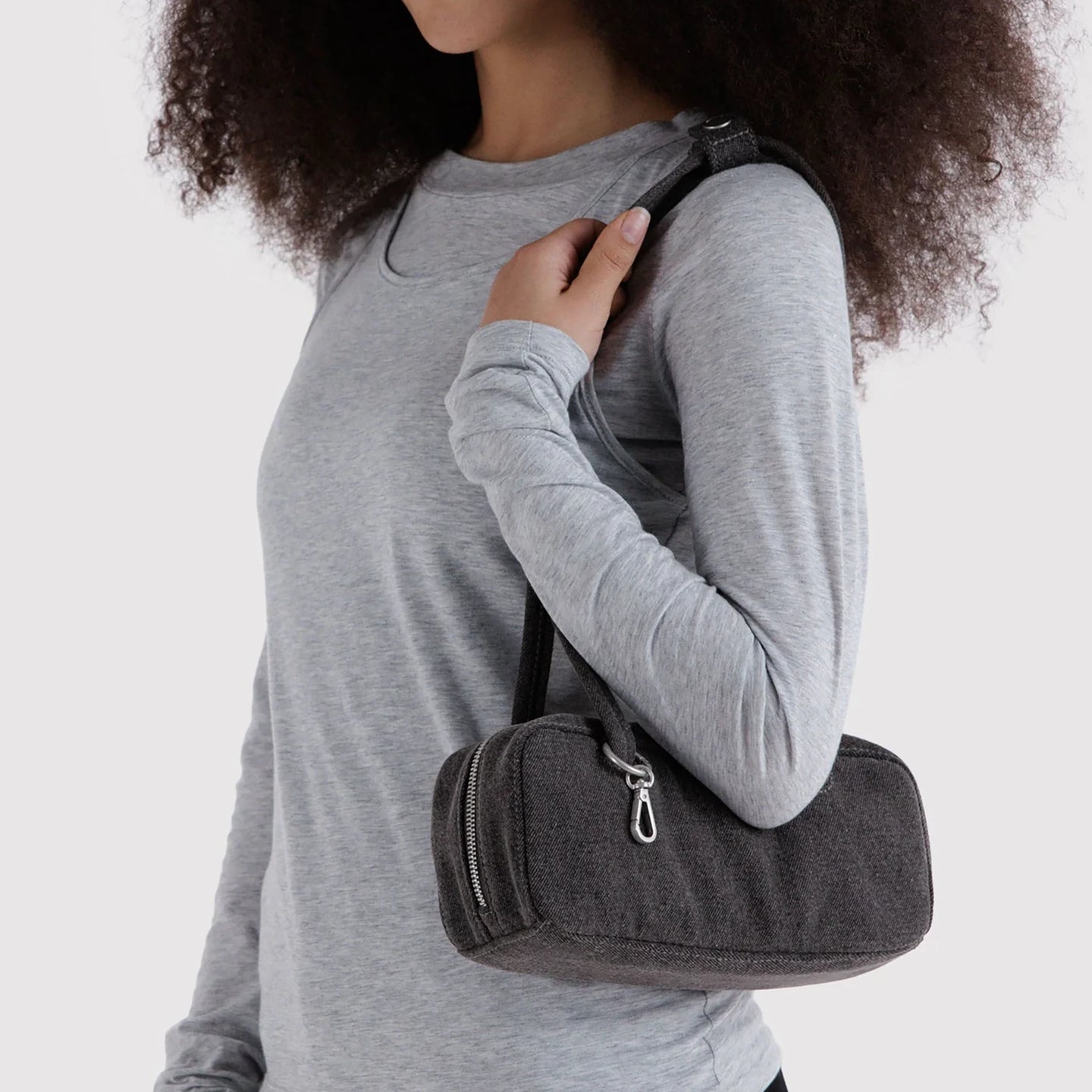 Small washed black denim bowler bag carried on shoulder with top zipper