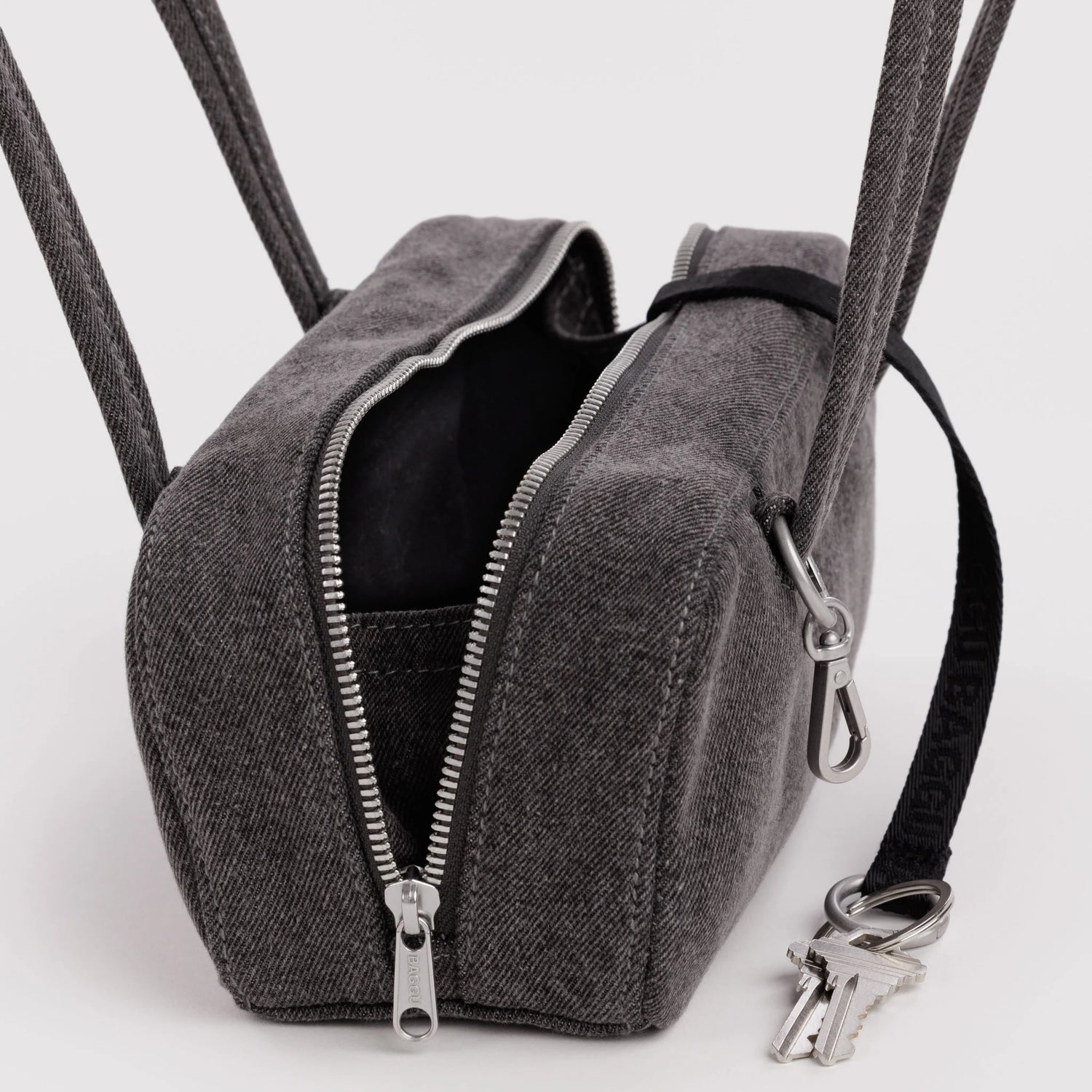 Washed black denim bowler bag with open top, black lining, dual zippers and key clip