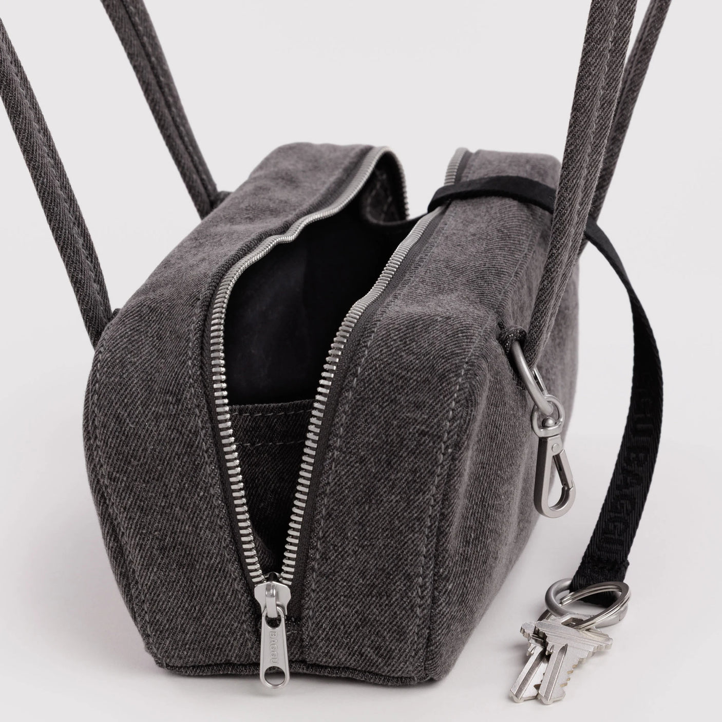 Washed black denim bowler bag with open top, black lining, dual zippers and key clip