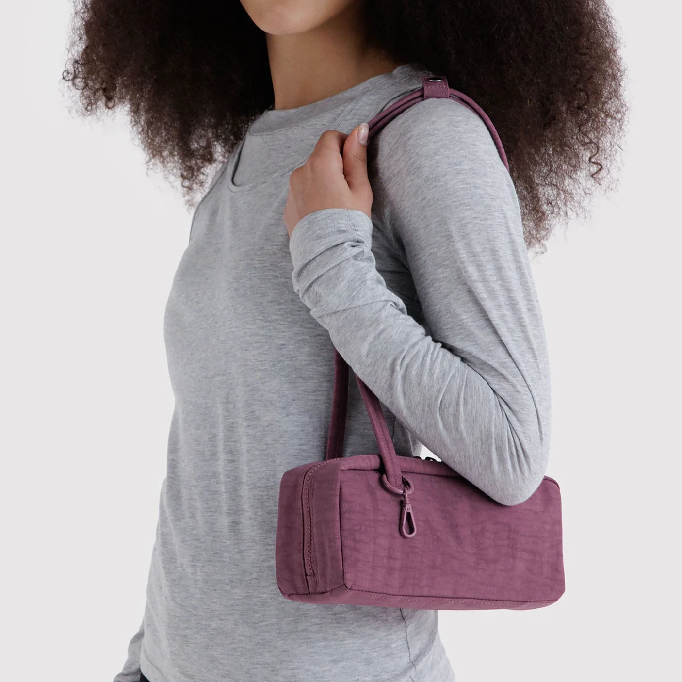 Small plum bowler bag carried on shoulder, two handles, zip closure