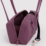Plum bowler bag with open zipper front, compartments inside, and keyring on side
