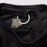 Black nylon crescent bag close-up: zipper, key clip, and metal ring