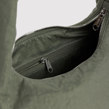 Olive-green nylon bag interior with zippered pocket and metal zipper pull