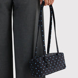 Small bowler bag with black base and sky-blue micro dots, held by a double top handle